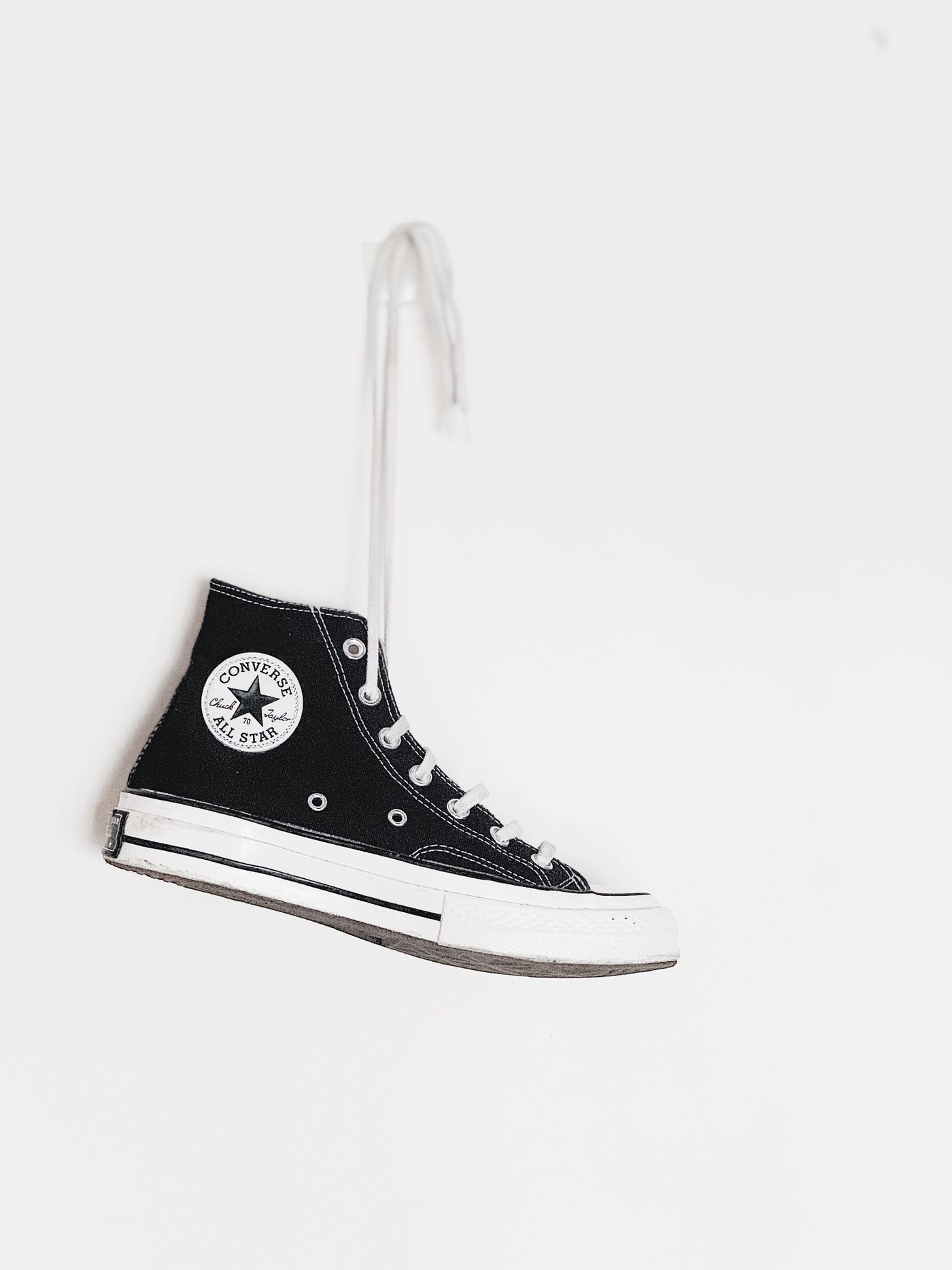 A single black high-top canvas sneaker photographed straight on against a plain white background with no props or text