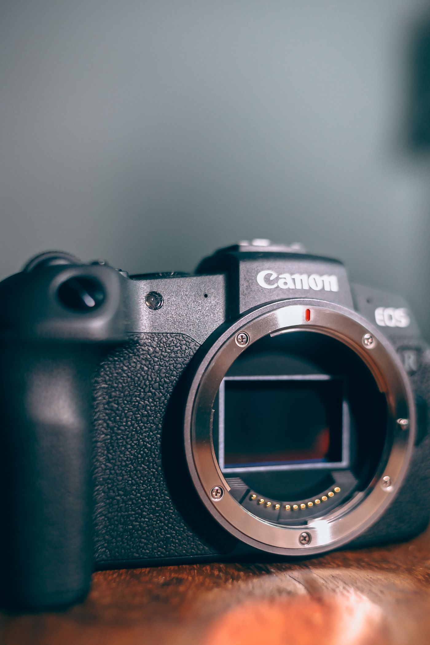 Close-up of a camera body with the lens removed, showing the open metal lens mount lying wider than it is tall