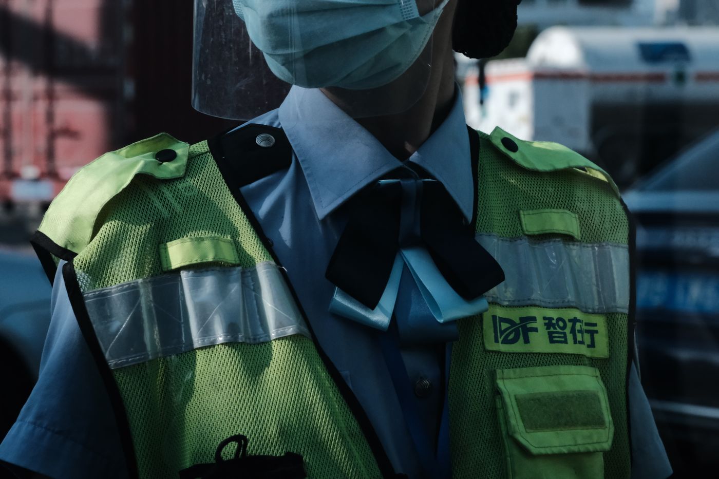 Close de um colete refletivo de alta visibilidade de um policial, com as faixas refletivas no peito registradas como uma faixa definida em vez de uma barra branca estourada