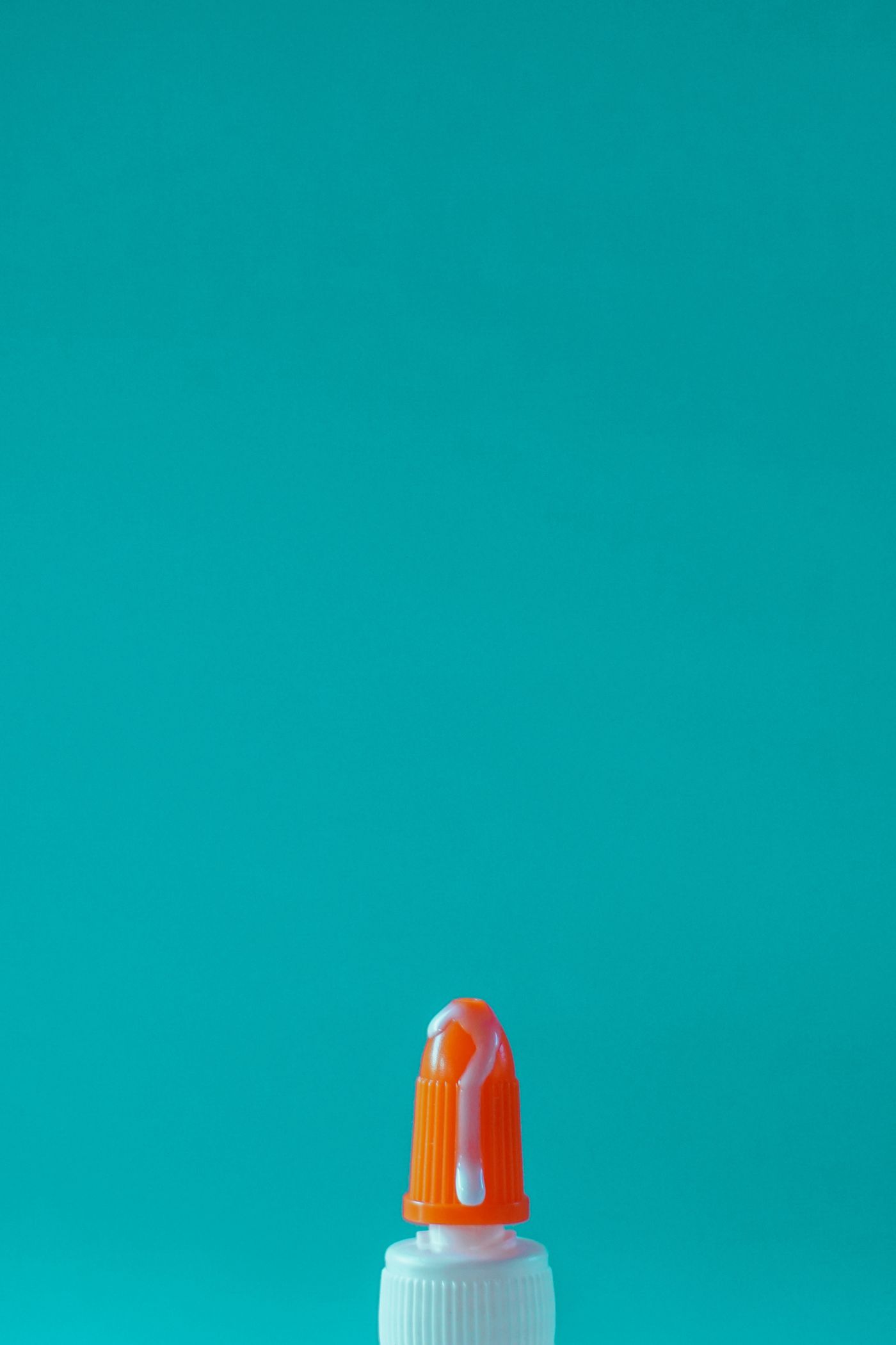 An orange water bottle photographed on a deep teal background, showing how complementary colors make a product stand out.