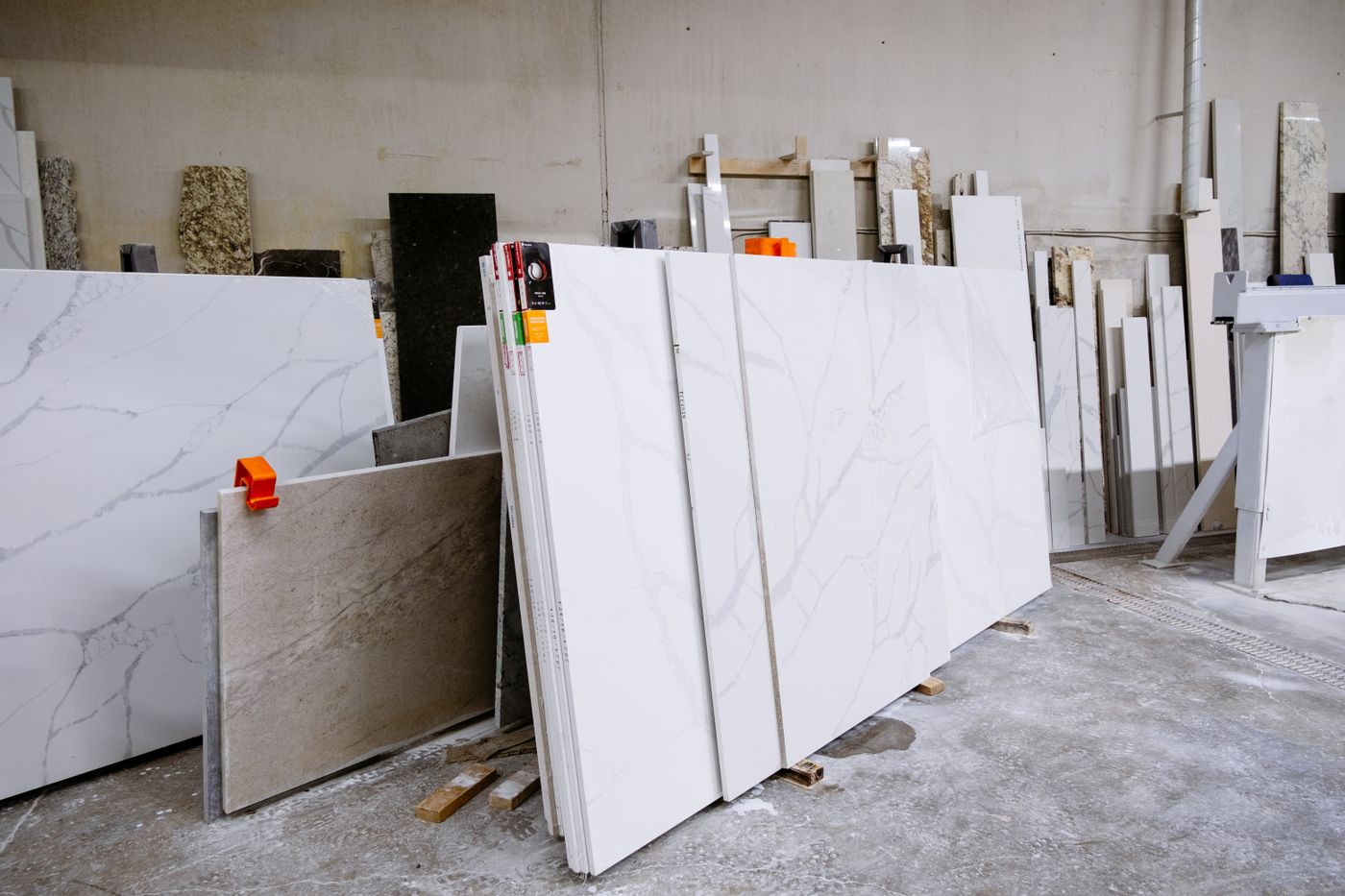 Granit- und Marmorplatten hochkant im Regal eines Steinmetzbetriebs, mit der ganzen Bandbreite verfügbarer Farben und Strukturen