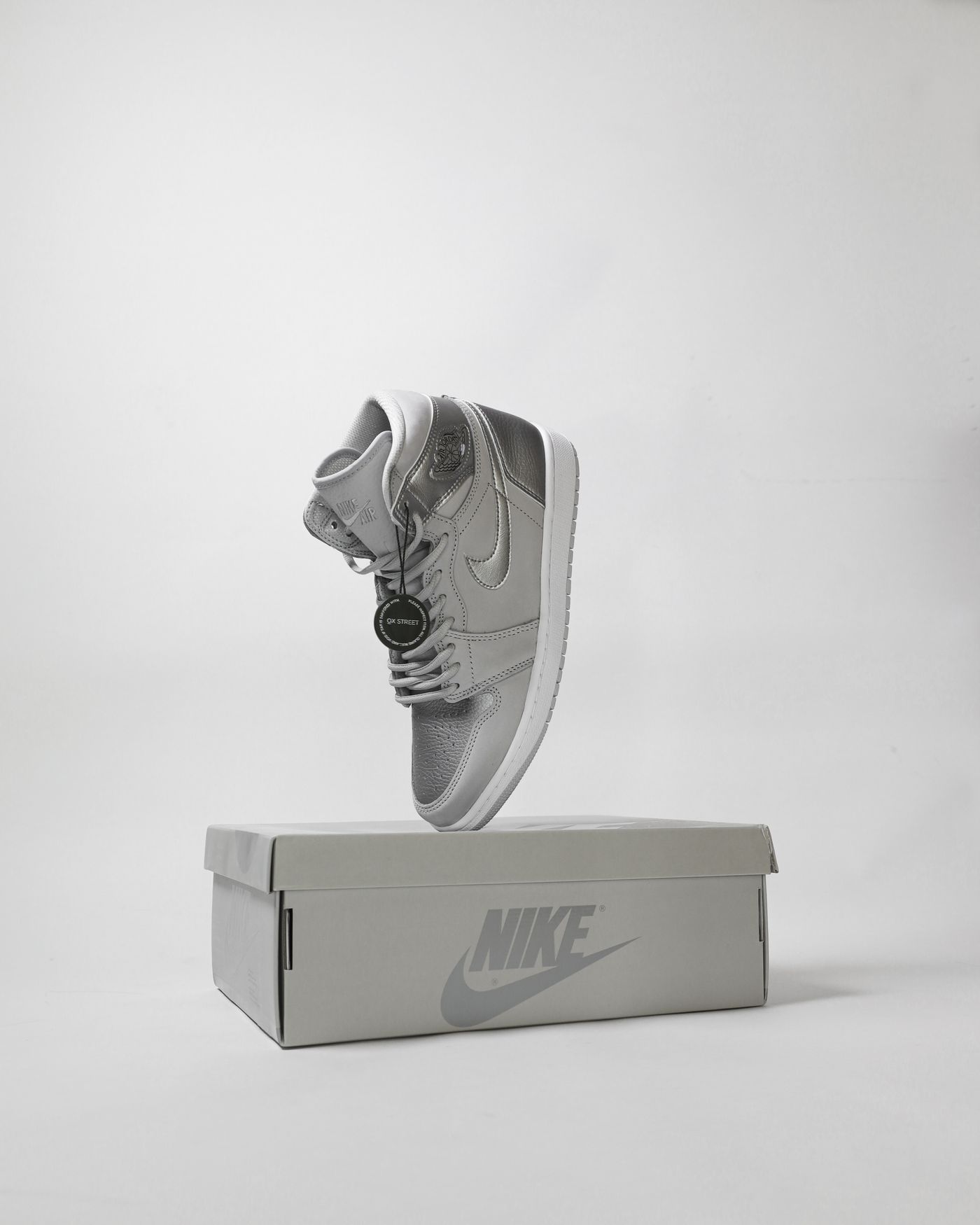 A sneaker photographed from the side with its outsole and original box laid out beside it for a resale listing